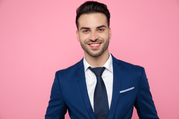 close up of attractive young man smiling on pink background