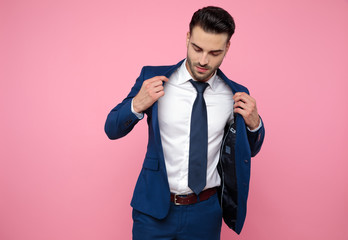 handsome casual man holding coat and looking down