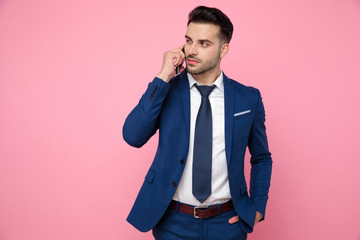 smart casual man talking on the phone on pink background