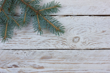 Flatlay greeting card with space for your text. Fluffy fir branch on a light wooden table.