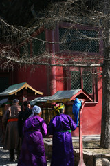 Unrecognisable Mongolian people in traditional clothing turning prayer mills in Vajradhara Temple, part of the Gandantegchinlen Monastery, Gandan , Great Place of Complete Joy, in Ulaan-Bator Mongolia