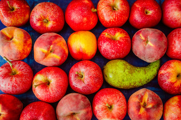 Apple with nectarine, peach and pear on blue background, raw healhy food concept
