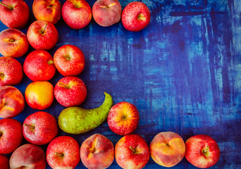 Apple with peach, nectarine, and pear on blue background, raw healhy food concept
