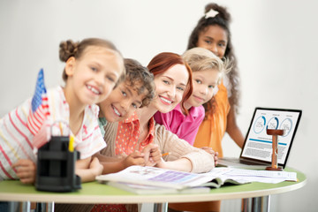 Obraz na płótnie Canvas Teacher and children sitting at the table near laptop