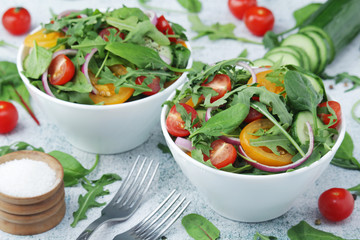 Two bowls full of vegetable salad	