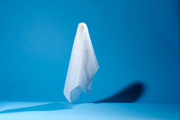 Picture of halloween ghosts from white fabric on blue background