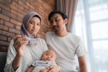 Obraz premium parent using thermometer to check their son condition at home