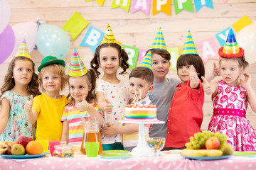 Kids group on party. Children celebrate birthday and show thumbs up