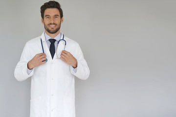 Smiling doctor standing on grey background