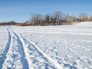 Fototapeta na wymiar Footprints on the snow in sunny winter day.