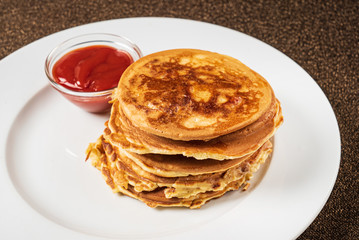 pancakes with strawberry sauce on the white plate
