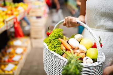 Woman holding a basket with healthy organic vegetables
