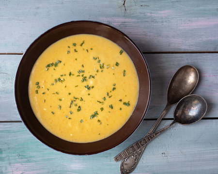 Homemade soup-mashed vegetables on mushroom broth in a deep dish and tablespoons