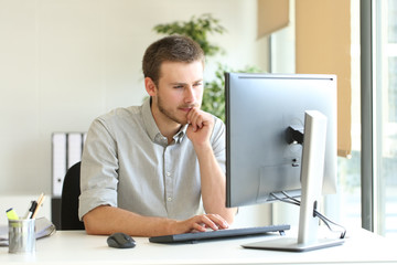 Concentrated businessman using computer at office