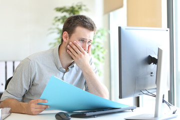 Worried businessman discovering mistake on computer