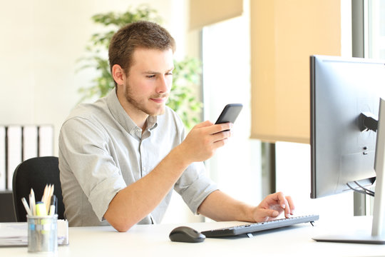 Serious office worker checking smart phone content