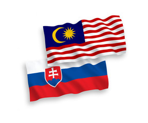 National vector fabric wave flags of Slovakia and Malaysia isolated on white background. 1 to 2 proportion.