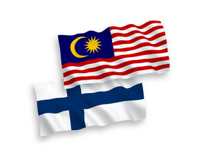 National vector fabric wave flags of Finland and Malaysia isolated on white background. 1 to 2 proportion.
