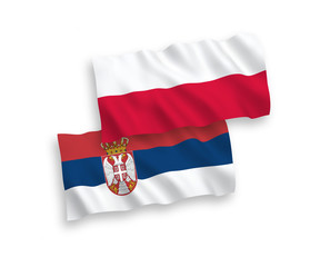 National vector fabric wave flags of Serbia and Poland isolated on white background. 1 to 2 proportion.