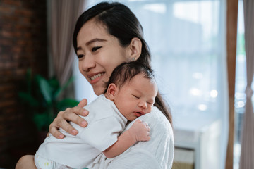Mother carrying adorable little daughter when spare time at home