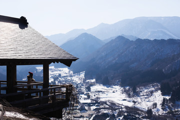 Young woman looking at an mountain in a white haze with sunlight winter in Japan