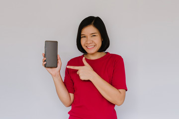 Happy smiling woman is pointing on smartphone on white background