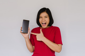 Happy smiling woman is pointing on smartphone on white background