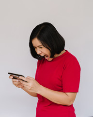 Very angry woman is shouting right on smartphone