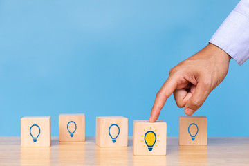 Businessman choose bright light bulb. Concept of Idea, solution and creative