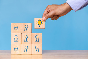 Hand hold wooden cube with choose bright light bulb. Concept of Idea, solution and creative