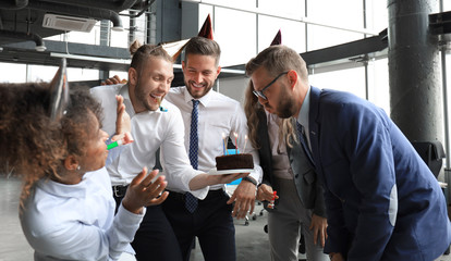 Business team celebrating a birthday of collegue in the modern office