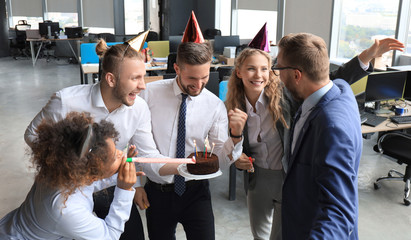 Business team celebrating a birthday of collegue in the modern office