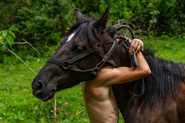man hugs horse by the neck