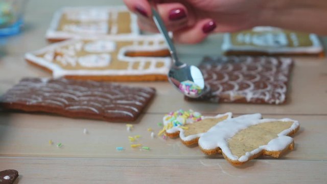 Young woman in the kitchen paints ginger Christmas gingerbread