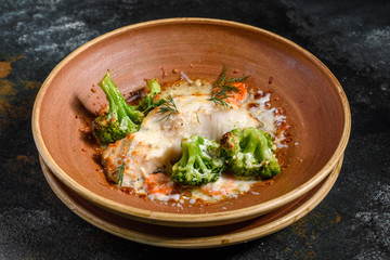 Fresh baked sea fish with broccoli, carrots, vegetables and cheese. Superfood. Vegitarian Menu