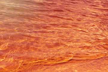 Beautiful texture of sea water on sunset. Water surface in sunset time. Waves background.