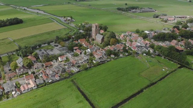 Aerial approach of the village Ransdorp with its agrarian surroundings near the city of Amsterdam in The Netherlands with clouds