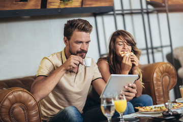 Shot of a young happy couple eating pizza in a restaurant