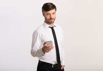 Man Holding Cellphone Standing On White Background