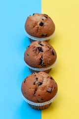 muffins with chocolate on blue and yellow background