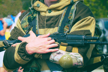 A soldier in camouflage uniform holding a machine gun