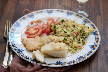 cod fish with quinoa and fresh salad on dish