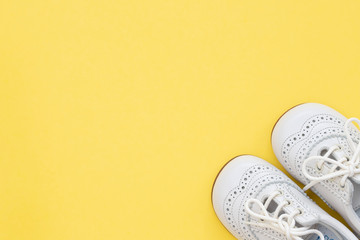 white baby shoes on yellow background