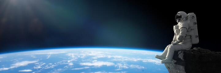 astronaut zittend op een klif op de maan voor planeet aarde