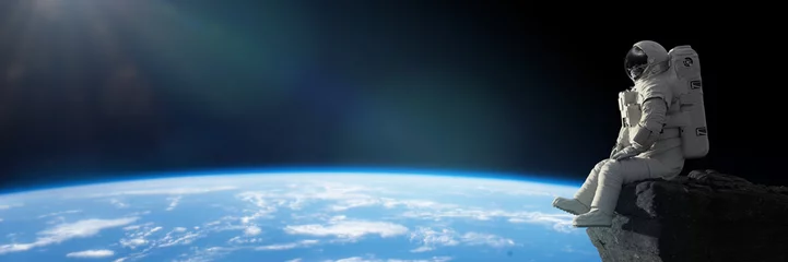 Crédence de cuisine en verre imprimé Chambre de garçon astronaute assis sur une falaise sur la Lune devant la planète Terre