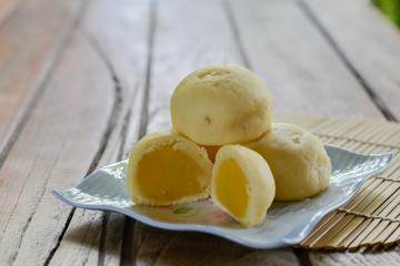 Thai style Mochi with Mung Bean stack on white plate  and wooden table with copy space for your text. Thai sweet dessert.