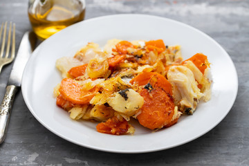 fried cod fish with sweet potato on white dish on ceramic background