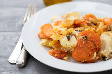 fried cod fish with sweet potato on white dish on ceramic background