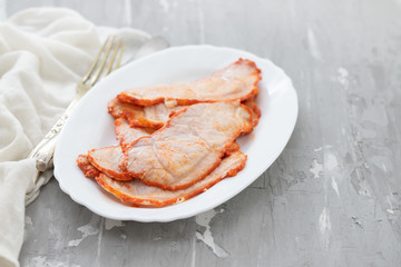 fried meat on white dish on ceramic background