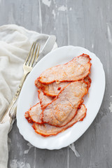 fried meat on white dish on ceramic background